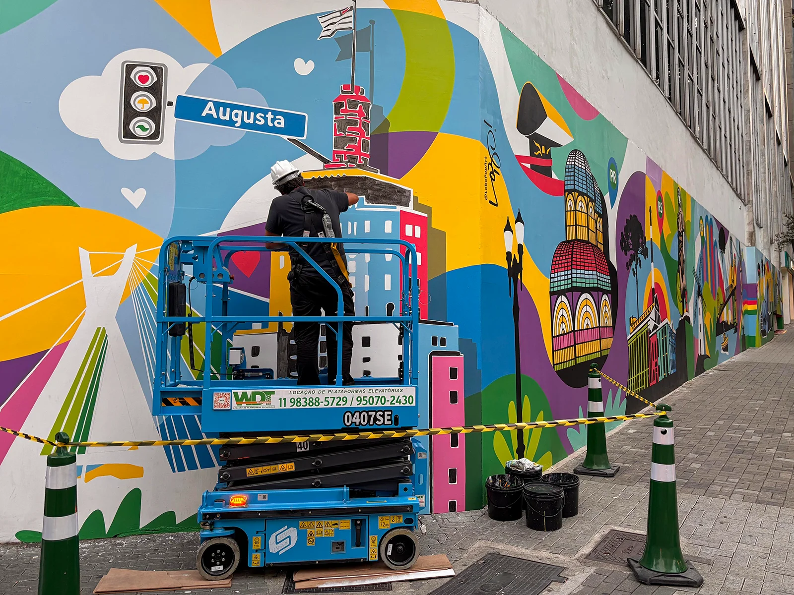 Lobo Pop Art trabalha em plataforma elevatória durante a pintura na Rua Augusta